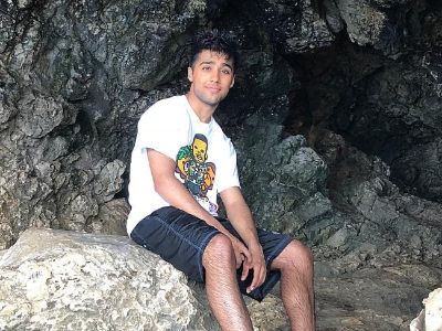 Chaniel Kular is sitting on a rock.